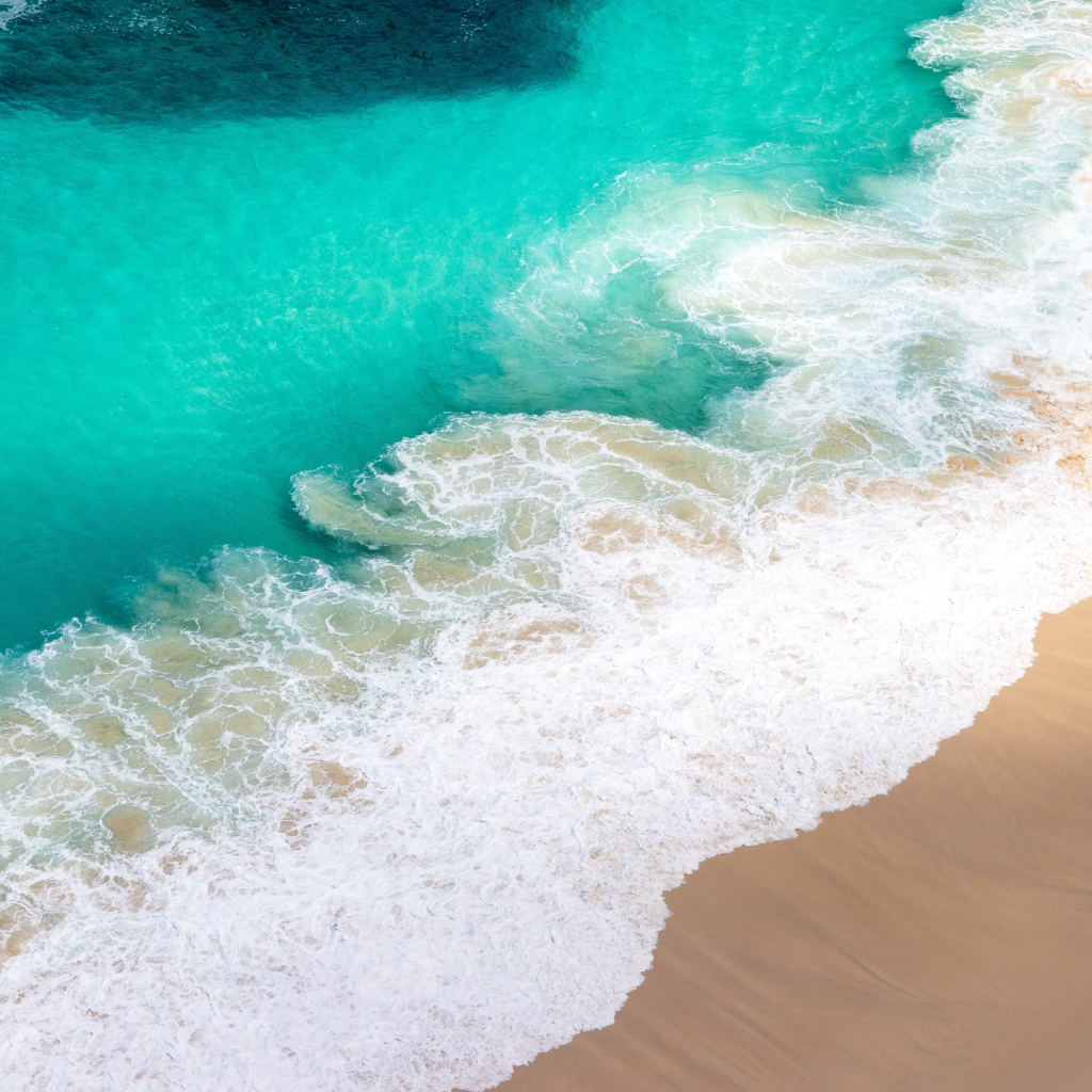 Вид сверху на белые волны прибоя 