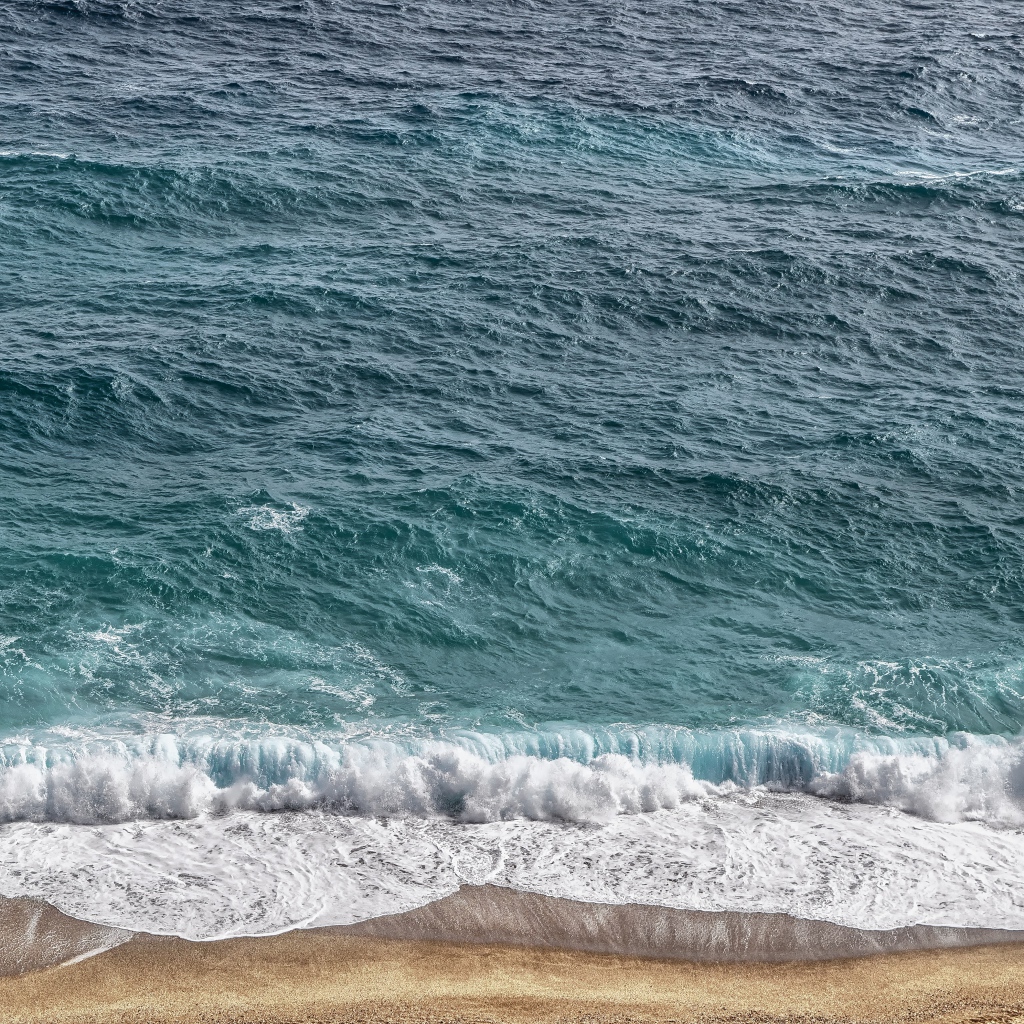 Белая пена от голубой морской воды на песке 