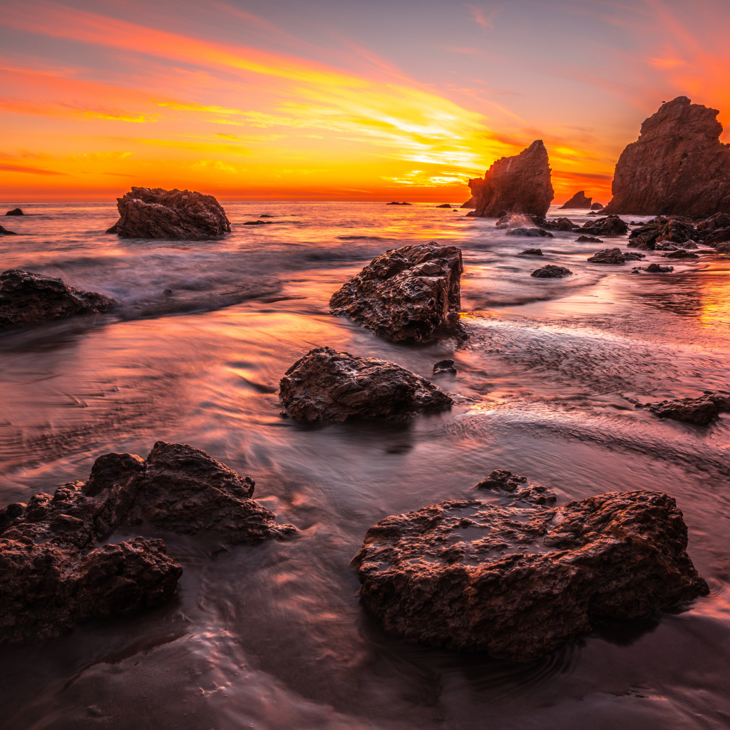 Красивый закат солнца на берегу моря с камнями 