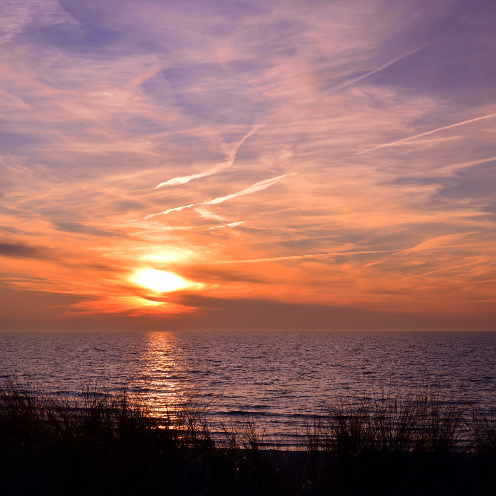 Закат солнца над спокойным озером летом