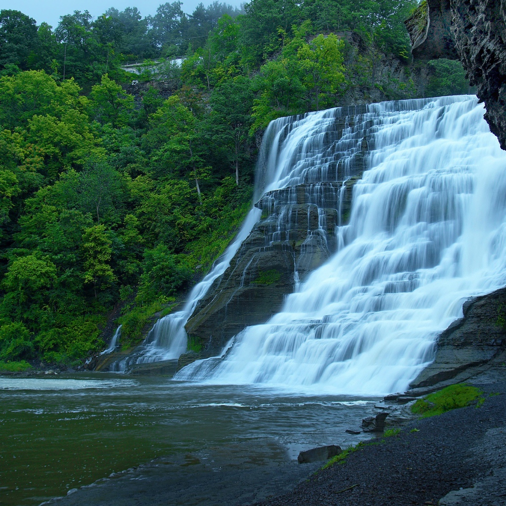 Красивый каскадный водопад с зелеными деревьями