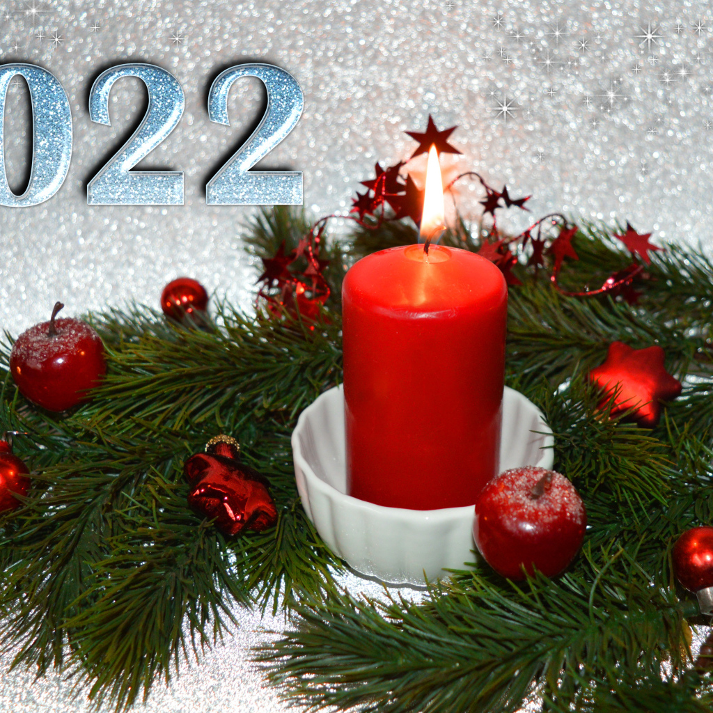Свеча и еловая ветка с украшениями на новый год 2022
