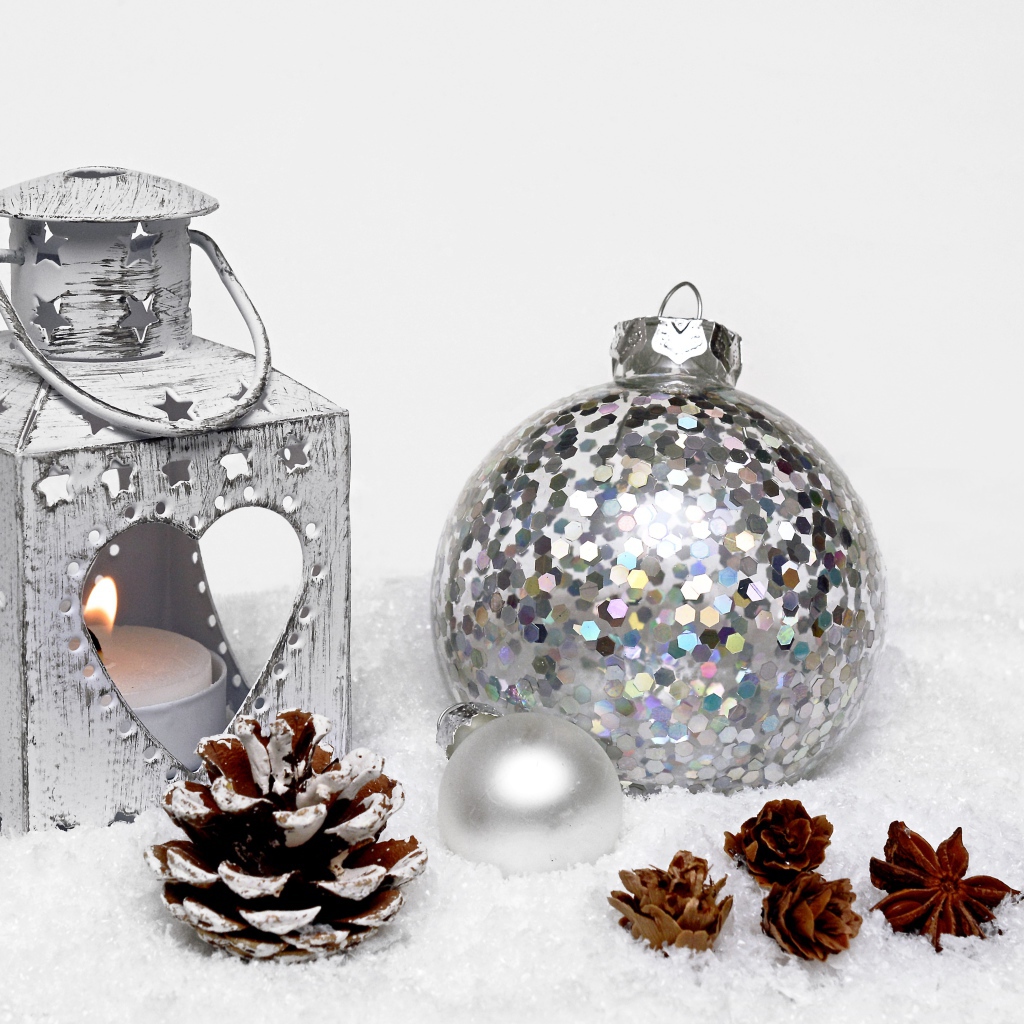 Фонарик и елочный шар с шишками на снегу