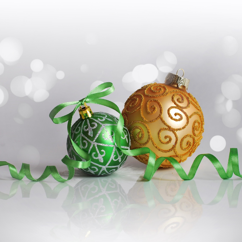 Два красивых елочных шарика с ленточкой на сером фоне 