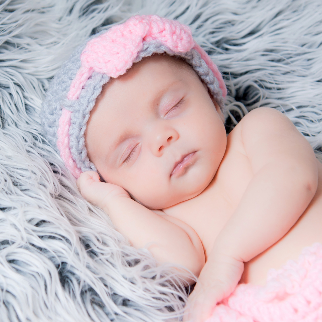 Грудной ребенок спит на меховом одеяле 