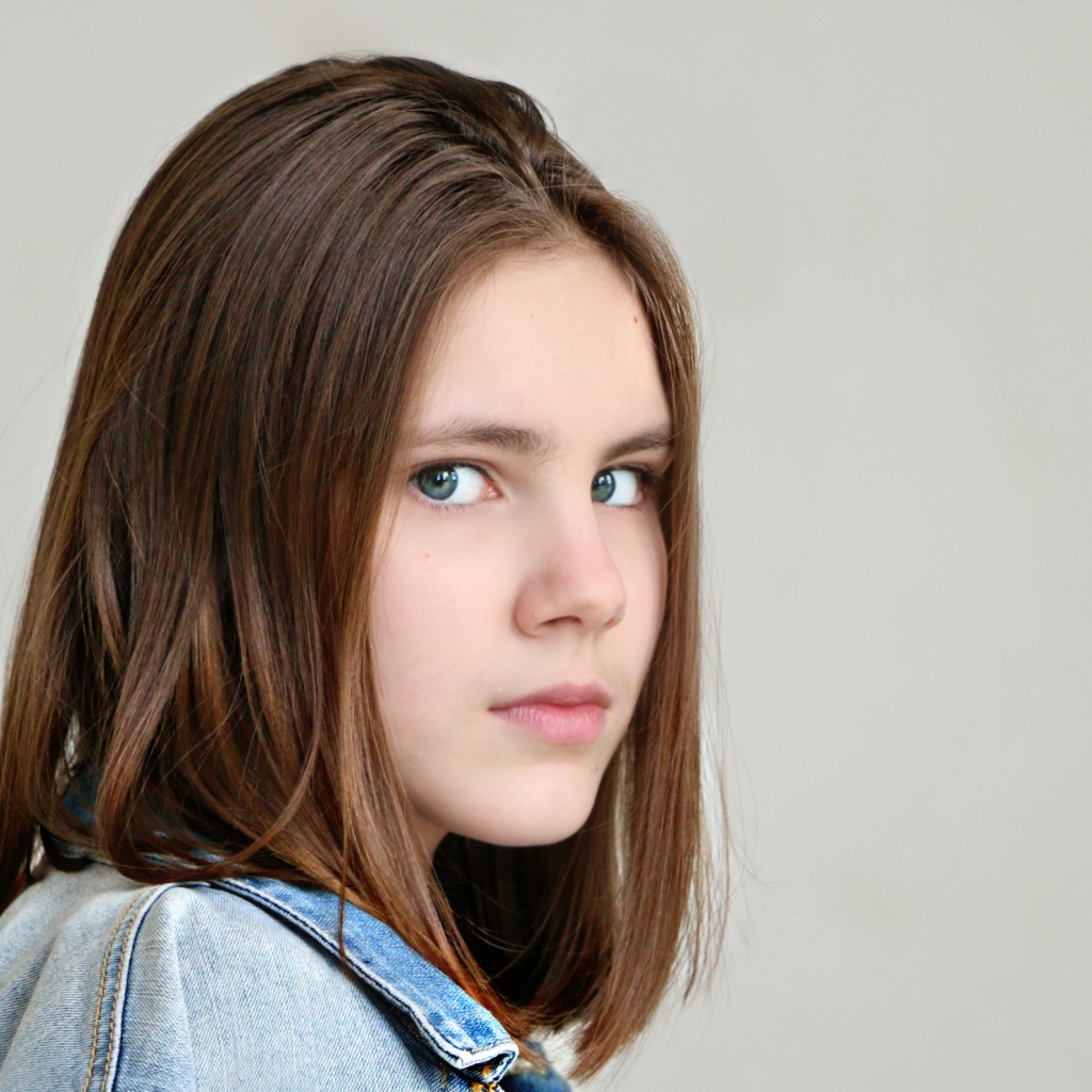 Красивая зеленоглазая девочка на сером фоне