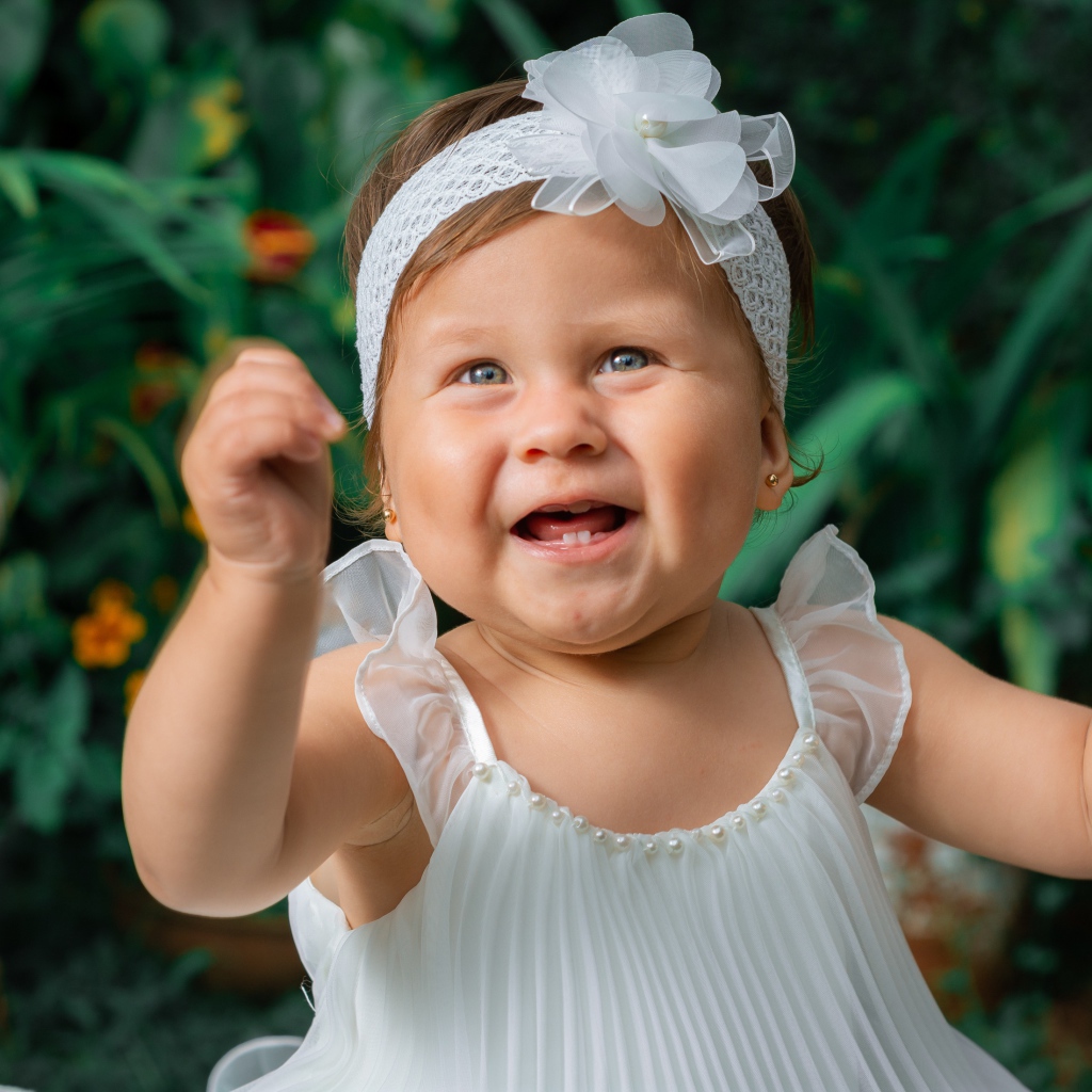 Красивая маленькая девочка в белом платье 