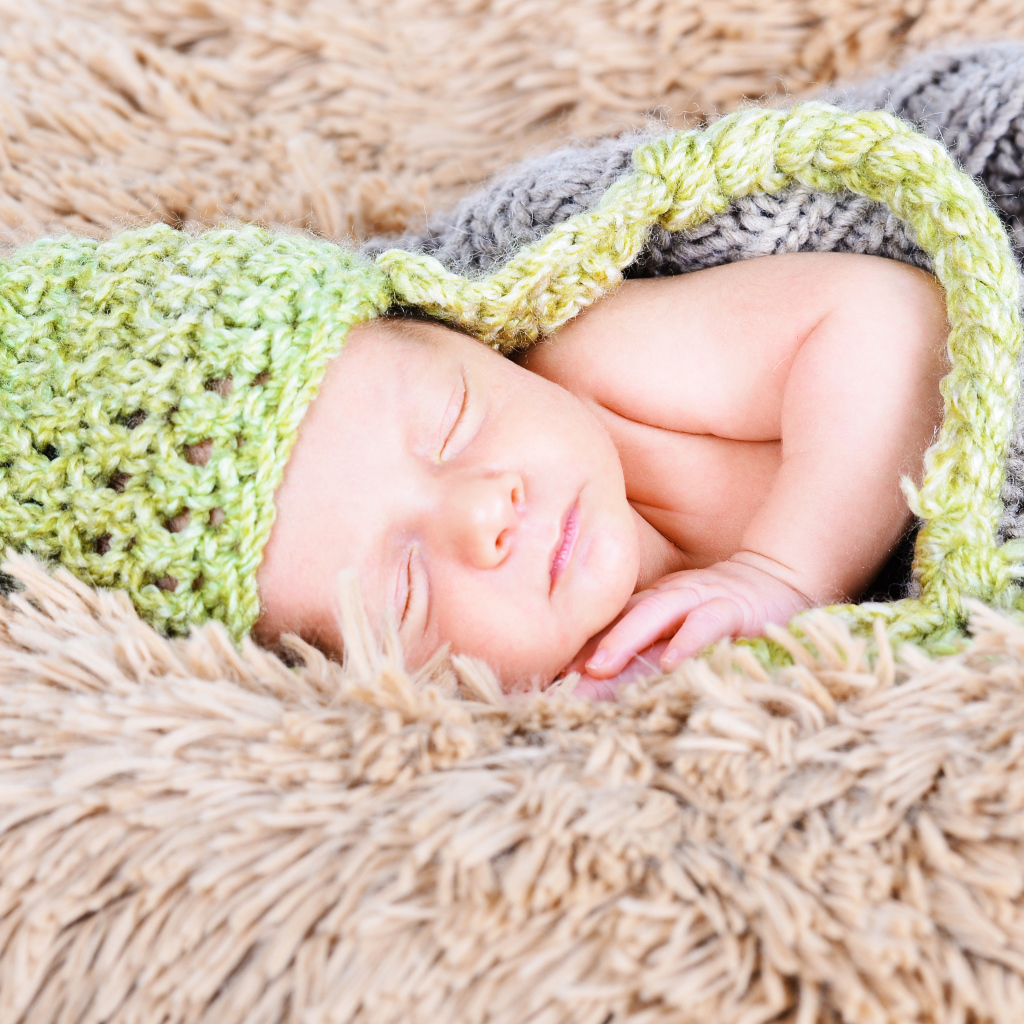 Красивый спящий грудной ребенок в вязаном костюме 