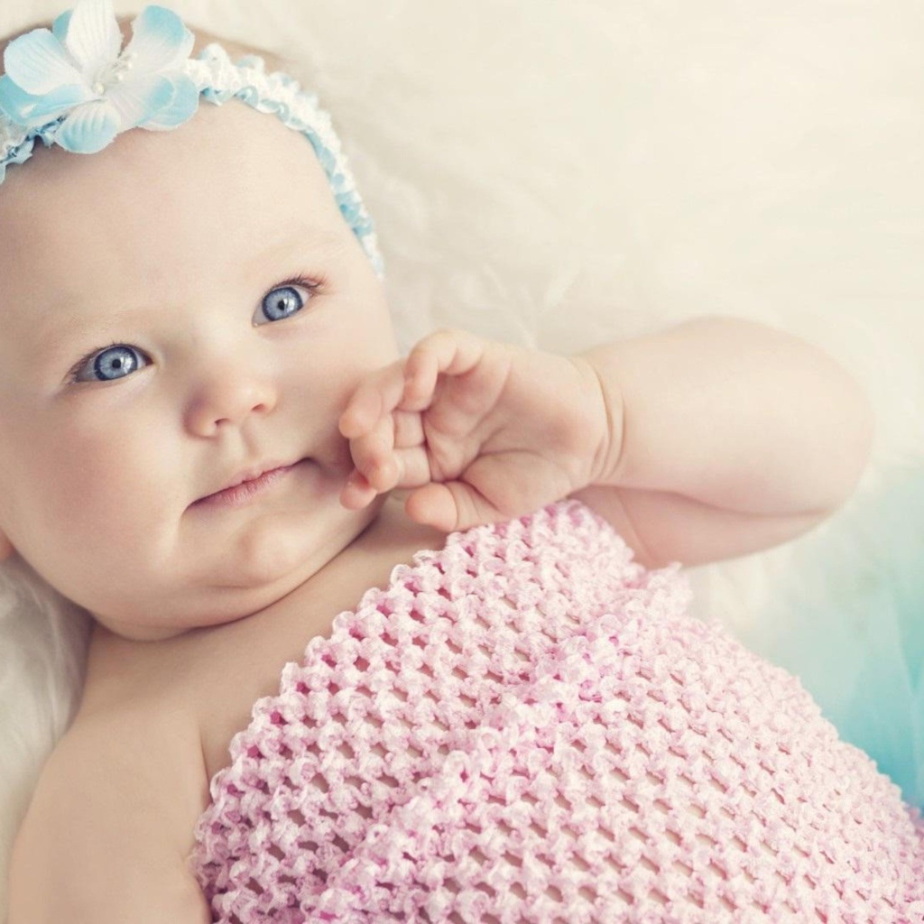 Голубоглазая маленькая девочка с повязкой на голове 