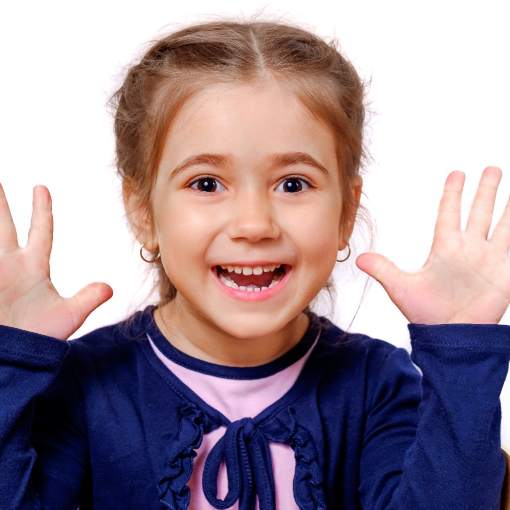 Веселая маленькая девочка с поднятыми руками