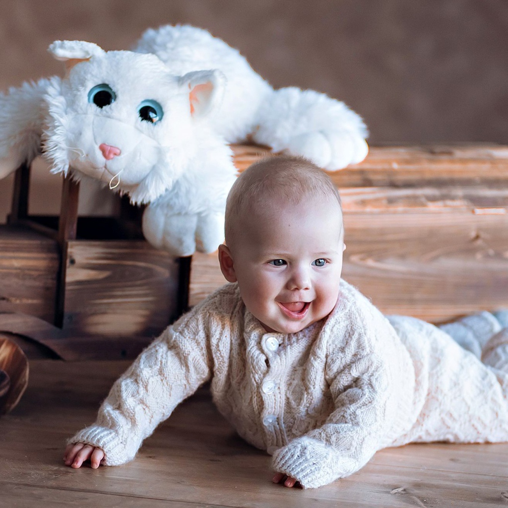 Веселый грудной ребенок с игрушечной машинкой 