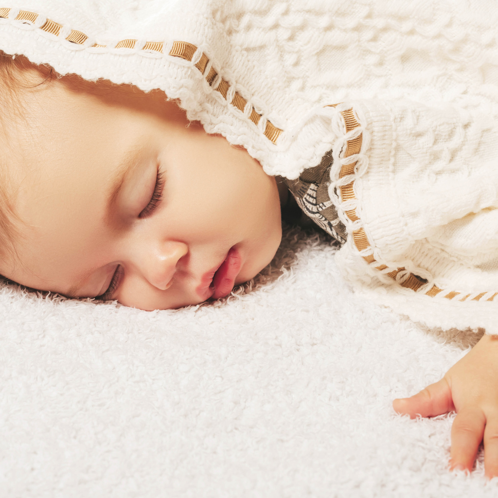 Милый спящий ребенок под покрывалом 