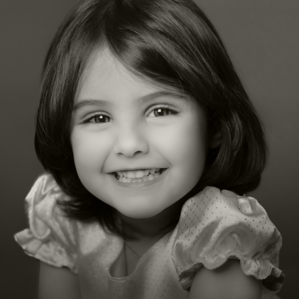 Милая улыбающаяся маленькая девочка черно-белое фото