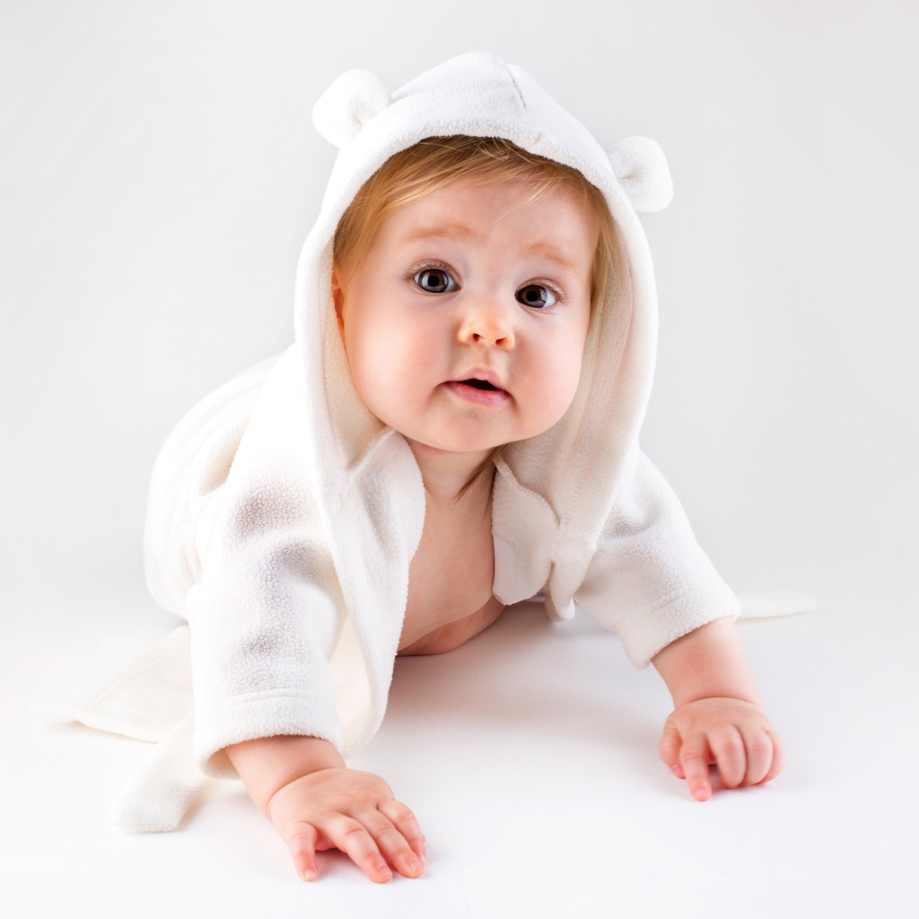 Забавный малыш ползает в белом наряде 