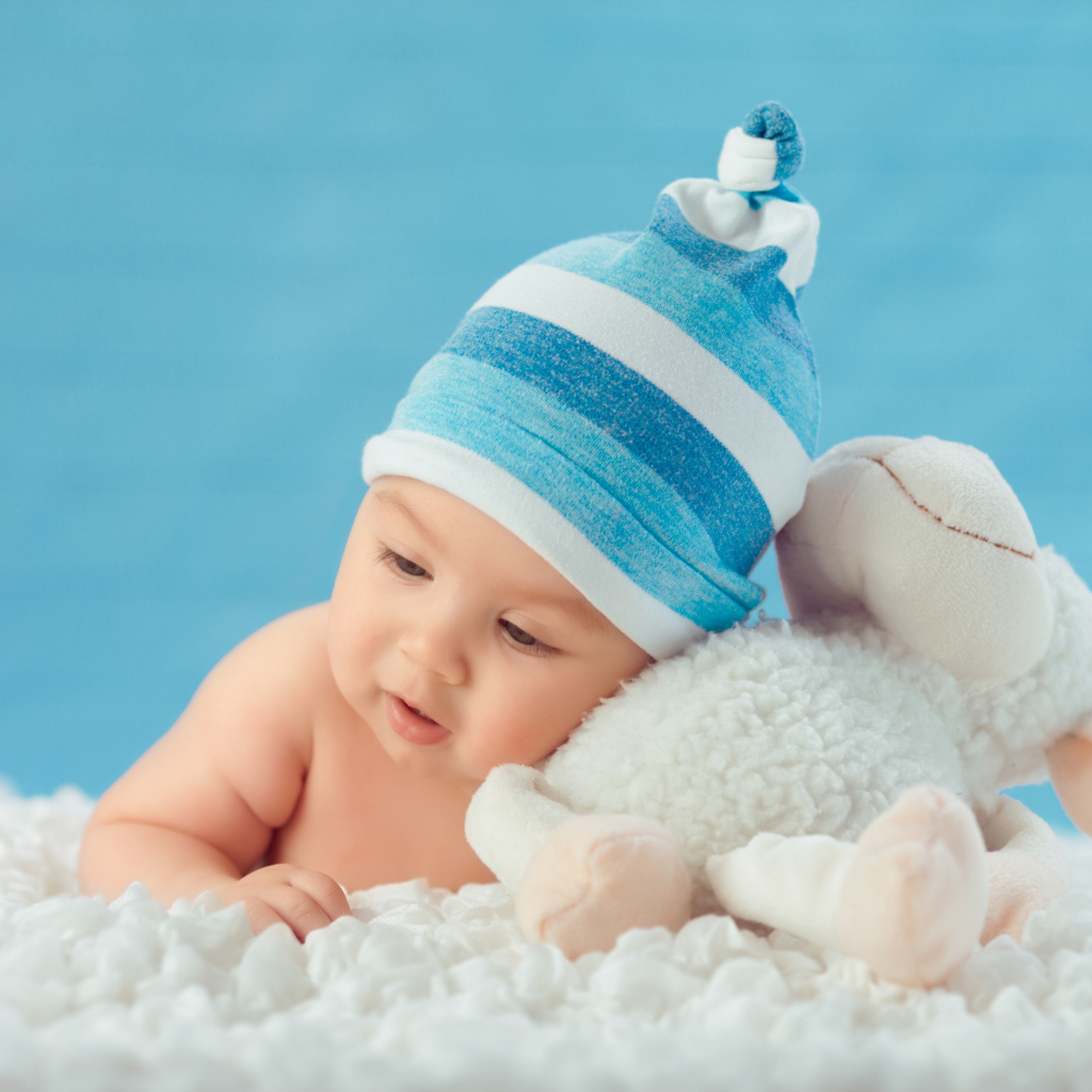 Забавный малыш с игрушкой на голубом фоне