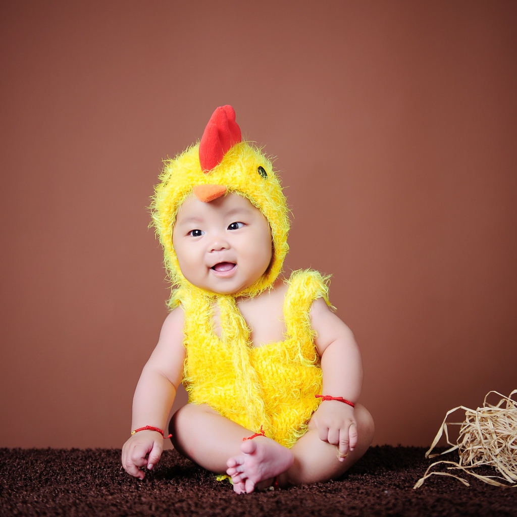 Маленький мальчик азиат в костюме цыпленка