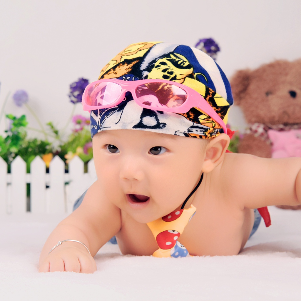 Маленький ребенок азиат в шапке с очками