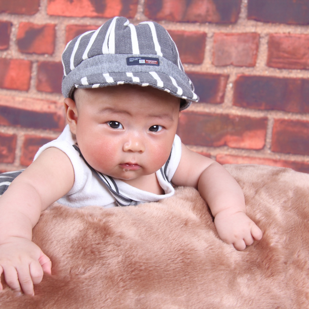 Маленький азиатский ребенок на фоне стены