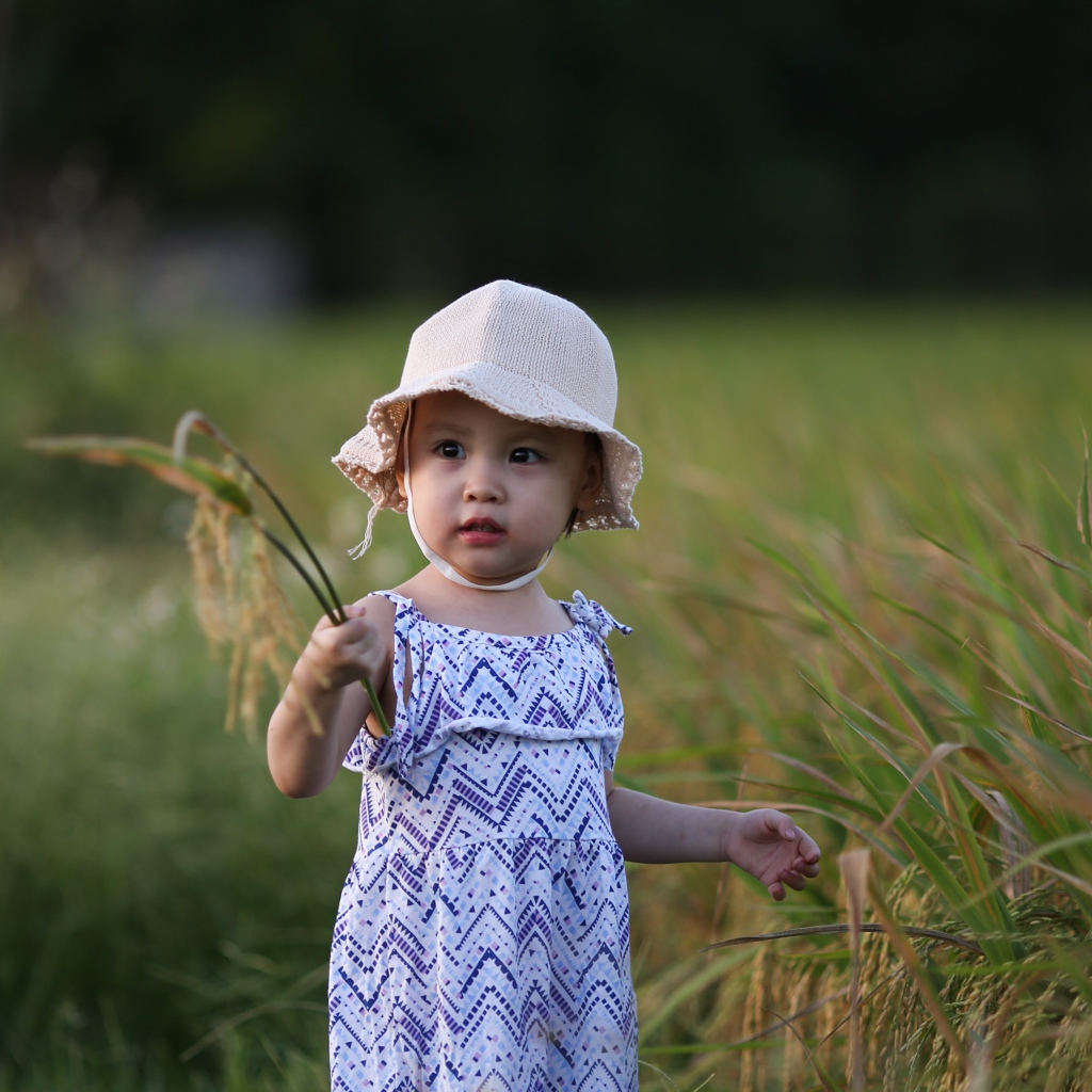 Маленькая девочка азиатка стоит в траве