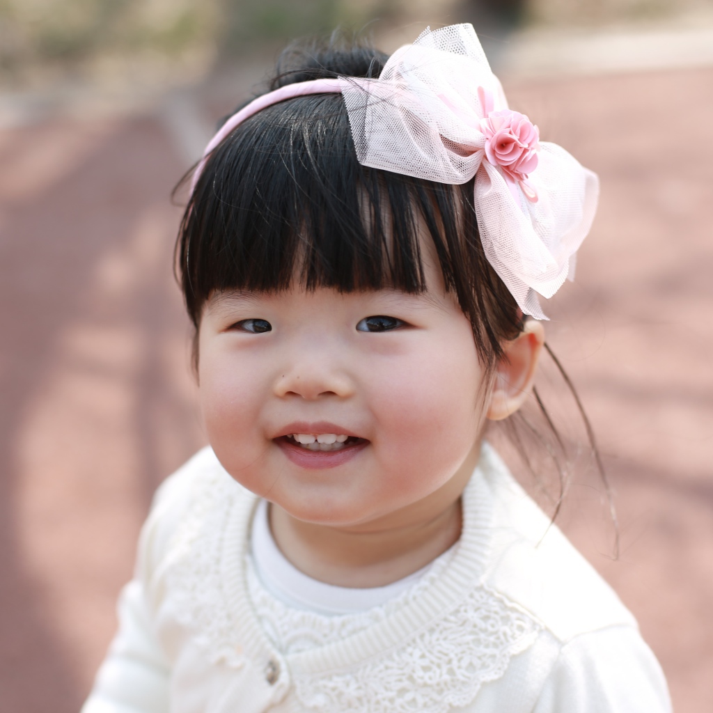 Маленькая девочка азиатка с бантом на голове 