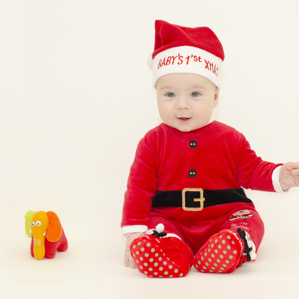 Маленький мальчик в новогоднем костюме на белом фоне