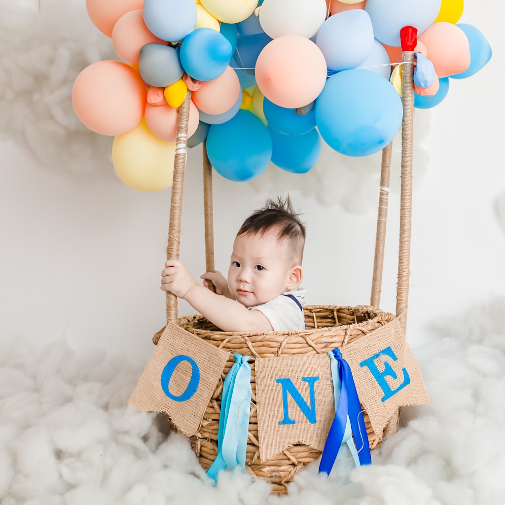 Маленький ребенок в корзине с шариками 