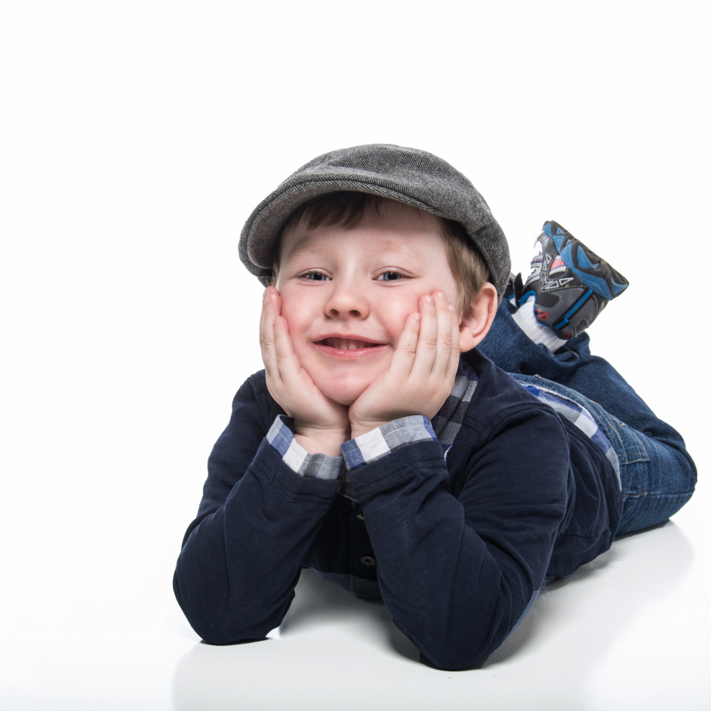 Маленький милый мальчик в кепке на белом фоне