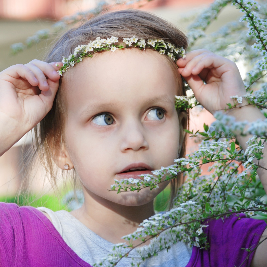 Маленькая девочка украсила голову белым цветком 