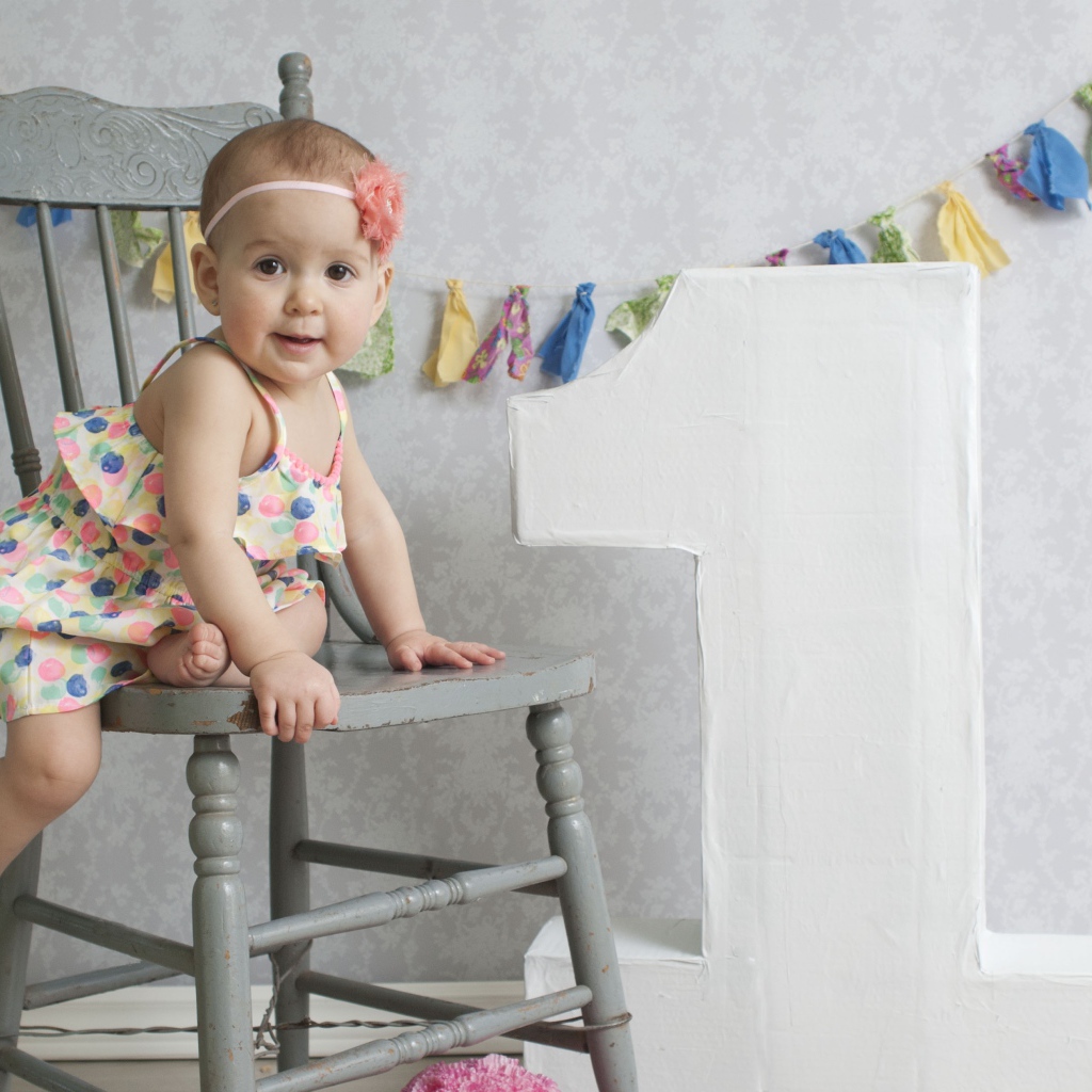 Маленькая девочка в платье на стуле