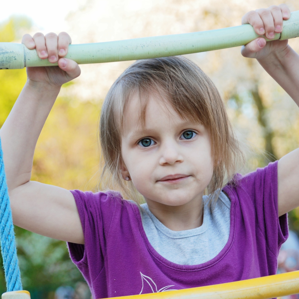 Маленькая девочка на подвесной лестнице 