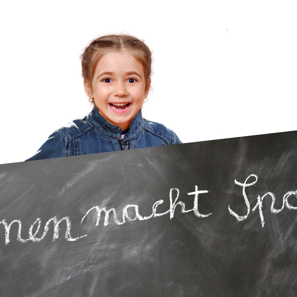 Маленькая девочка школьница с доской на белом фоне