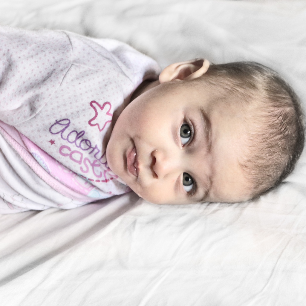 Маленький новорожденный ребенок лежит на кровати 