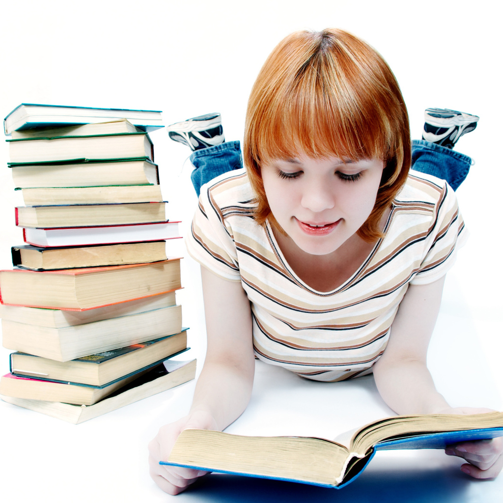 Рыжеволосая девочка школьница с книгами на белом фоне 