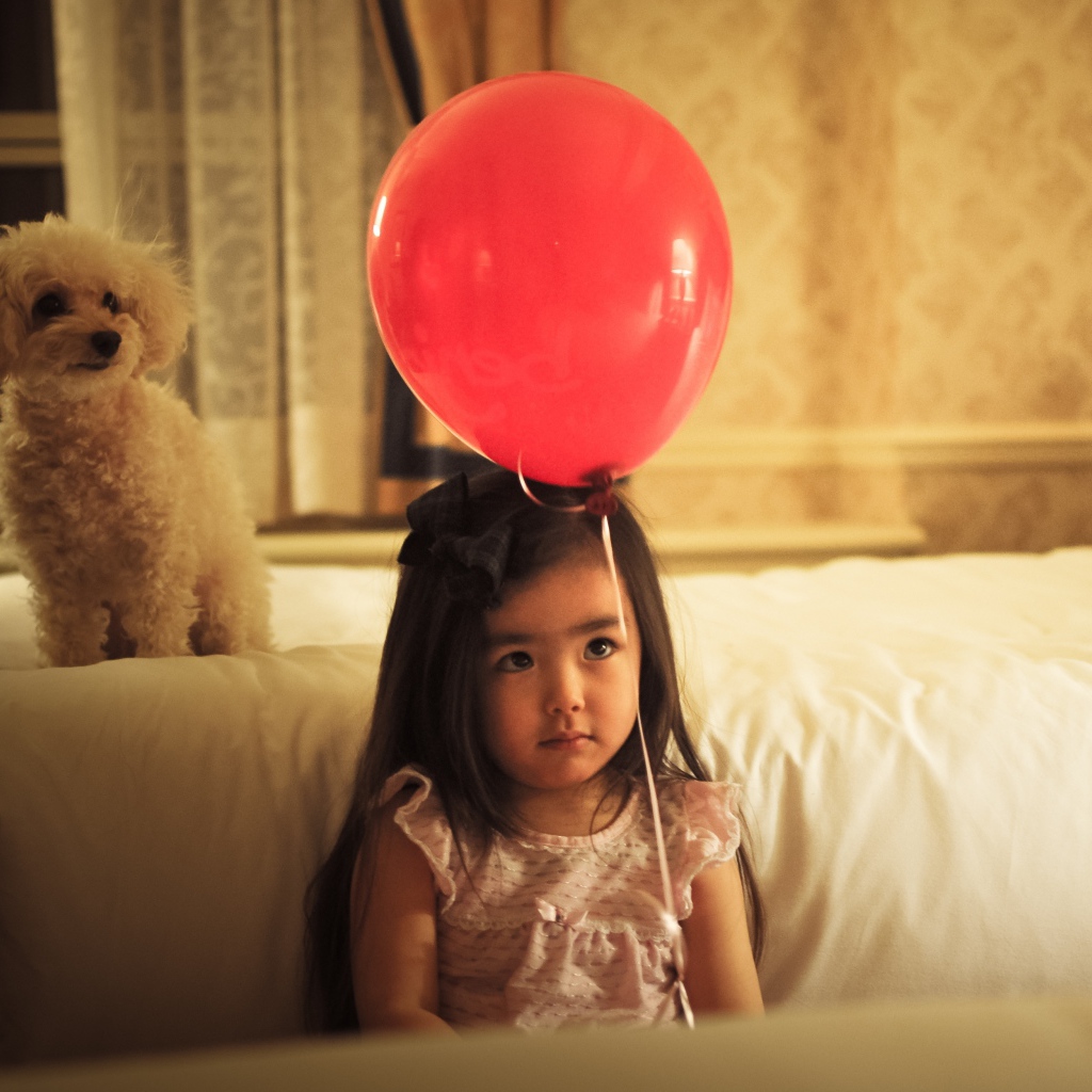 Грустная девочка азиатка с красным шариком