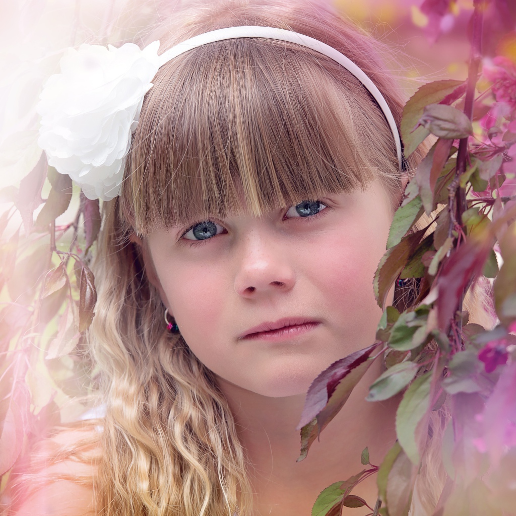 Грустная маленькая девочка у ветки дерева 