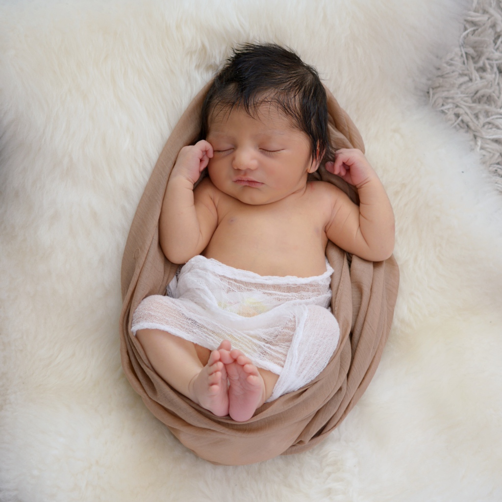 Спящий грудной ребенок на меховом покрывале 