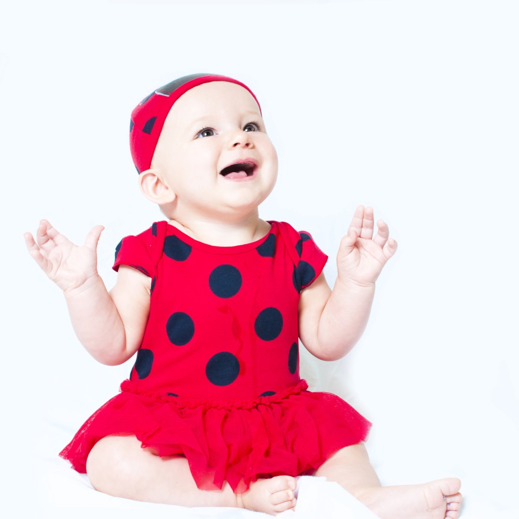 Улыбающаяся девочка в красном платье с черными кругами