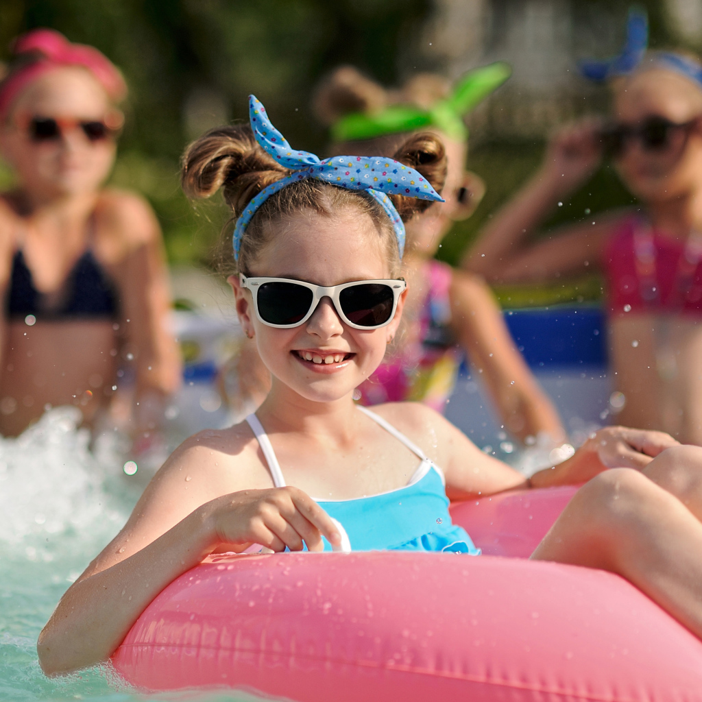 Улыбающаяся девочка со спасательным кругом в бассейне 