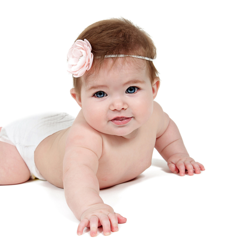 Улыбающаяся маленькая голубоглазая малышка на белом фоне 