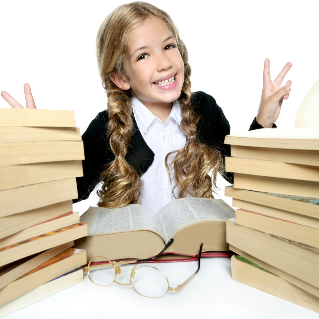 Улыбающаяся девочка школьница с книгами на белом фоне