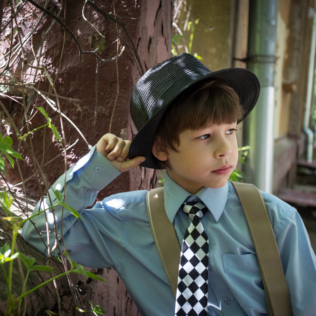 Стильный мальчик в черной шляпе 