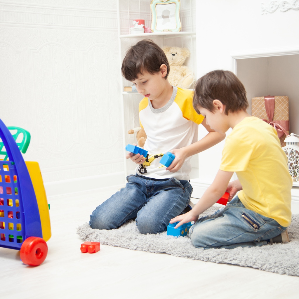 Два маленьких мальчика играет на полу