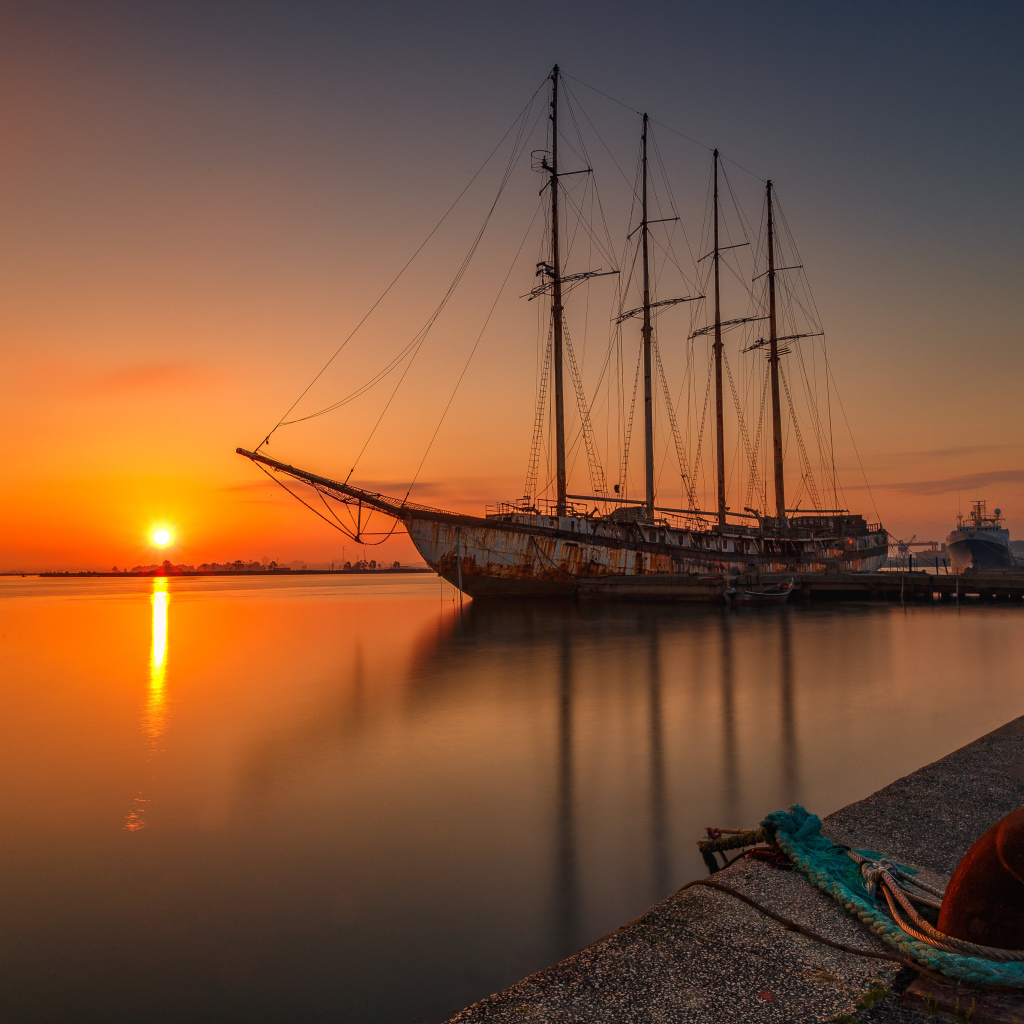Большой корабль стоит на закате солнца 