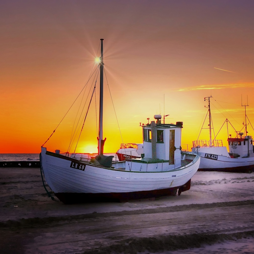 Рыбацкая лодка на берегу на закате 
