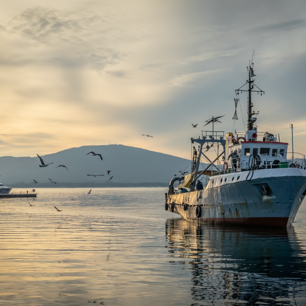 Old fishing boat at sea at sunset