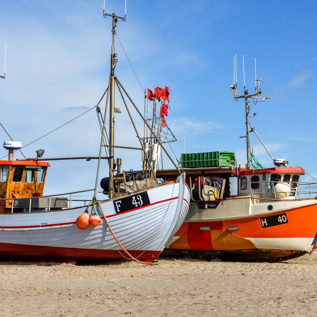 Две рыбацкие лодки стоят на песке у моря 