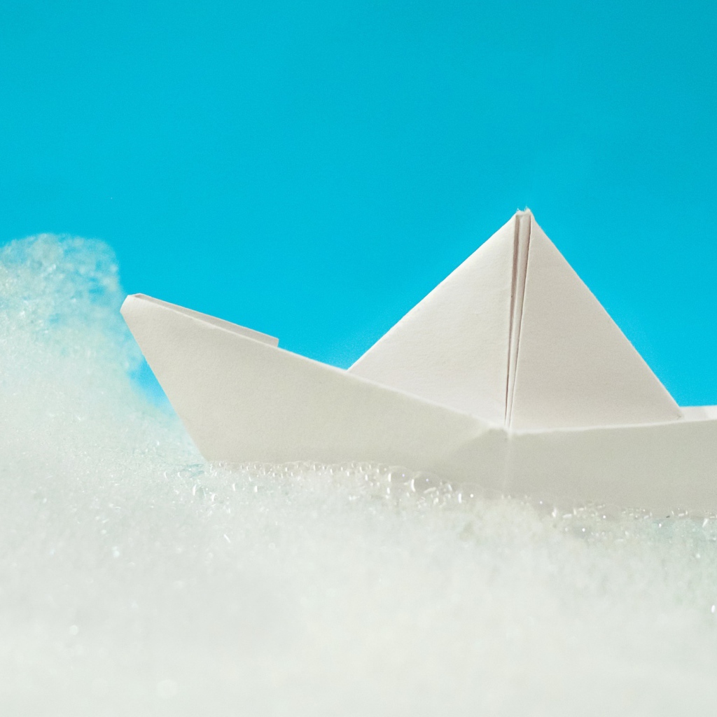 White paper boat on foam on a blue background