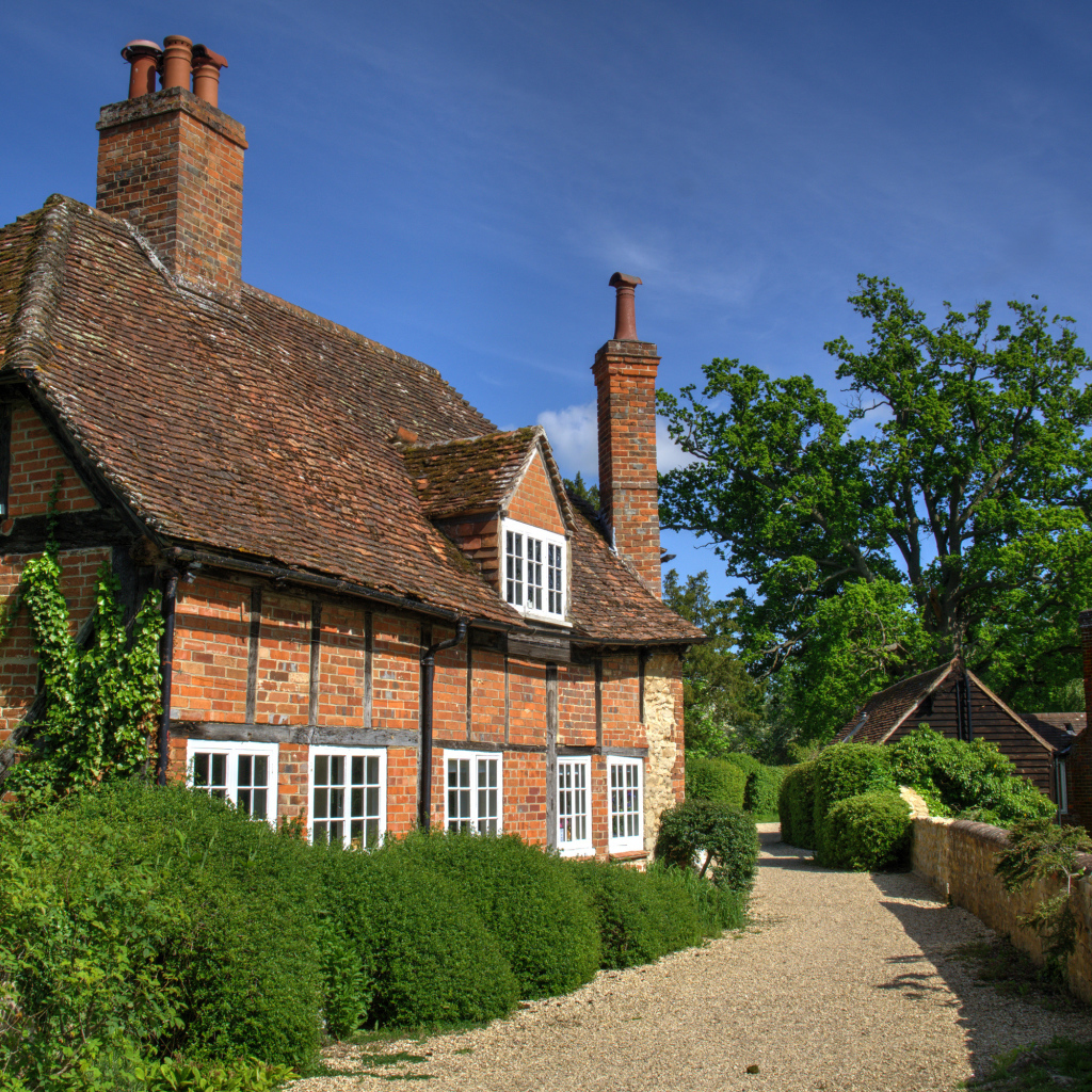 Кирпичный старый дом под голубым небом, Англия 