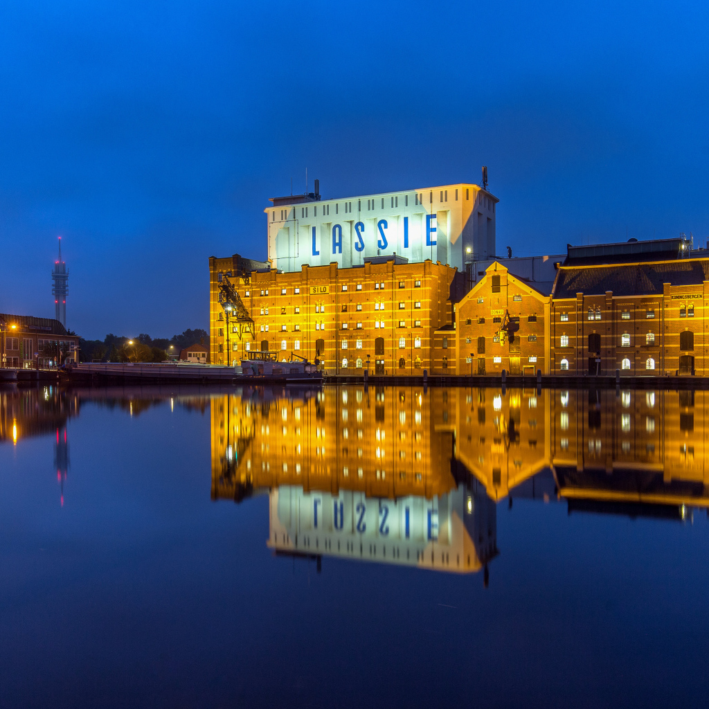 Здание завода у воды ночью, Нидерланды