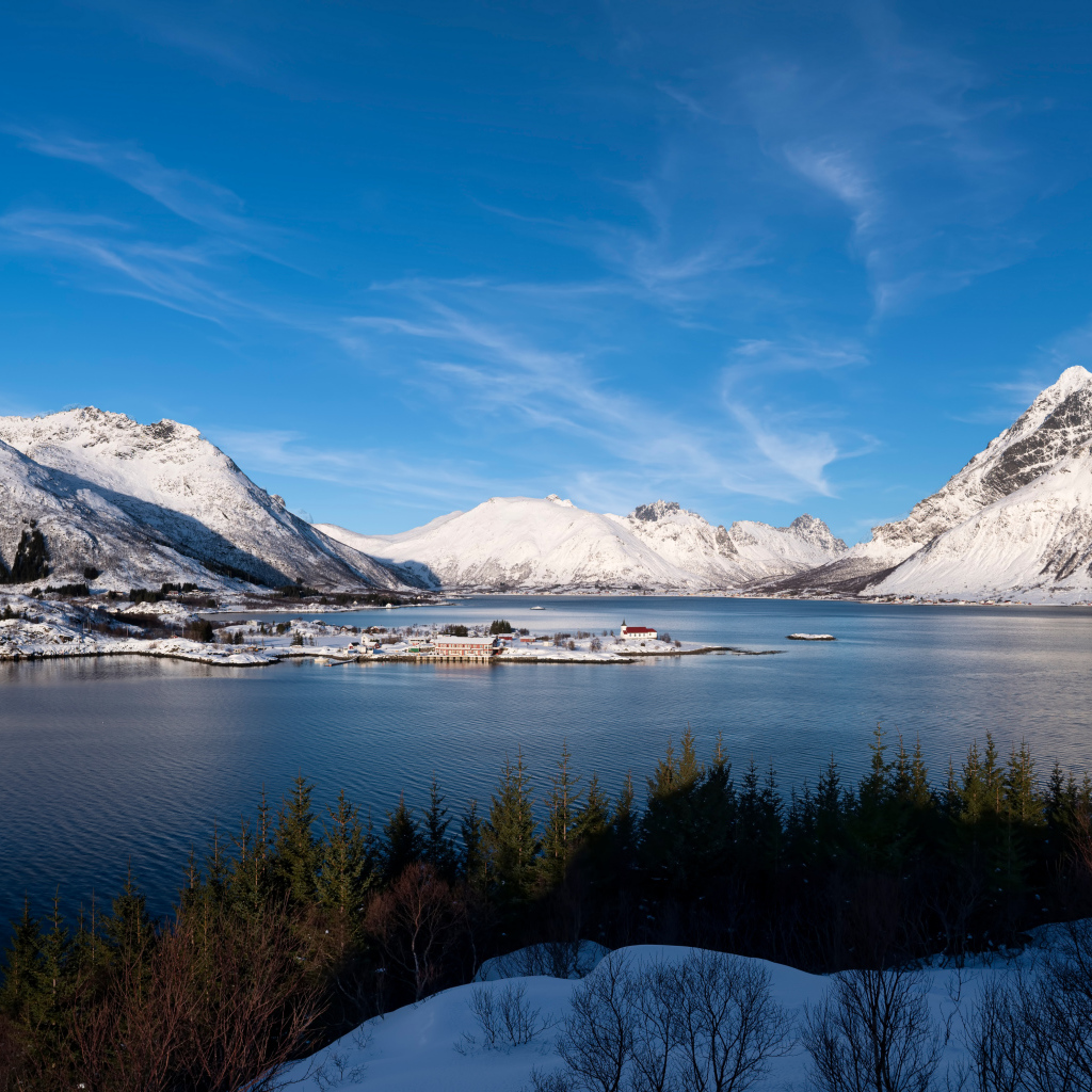 Покрытые снегом горы под голубым небом у воды, Норвегия